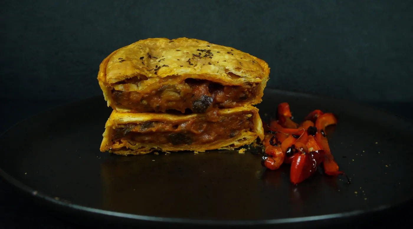 A reheated Eggplant Parmigiana pie on a plate